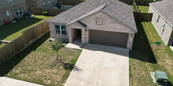 A brick house with a two-car garage and a concrete driveway.