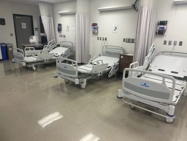 Empty Simulation lab room multiple beds and privacy curtains. Costcare Accubed