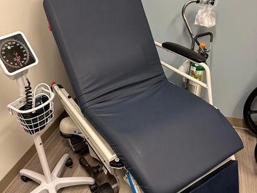 Empty medical examination chair with blood pressure monitor. Welch Allyn and Stryker 5050