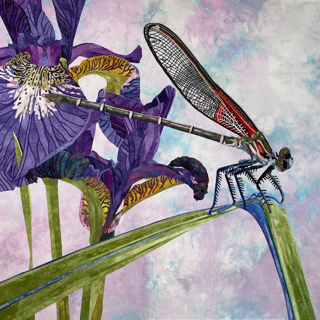 Fabric collage of a Rubyspot Damselfly perched on a leaf in front of two iris flowers