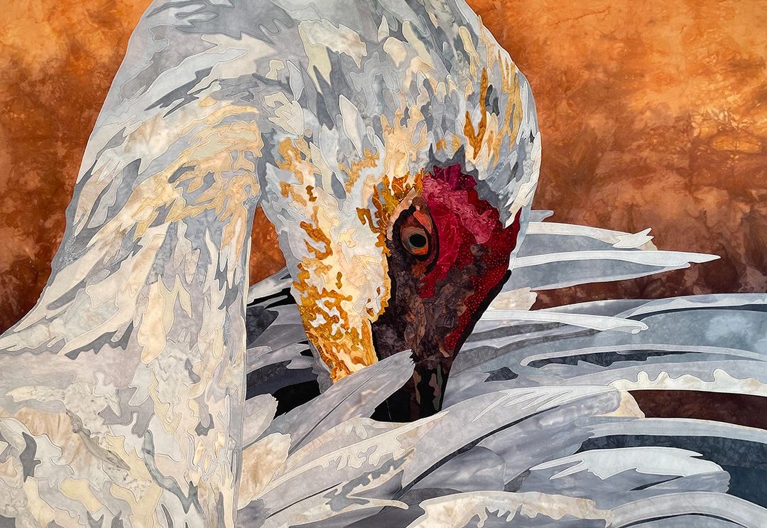 Fabric collage of a Sandhill Crane with its head tucked under a wing
