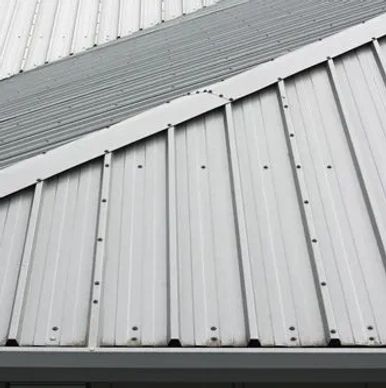 Close-up of a metal roof with overlapping panels and visible fasteners.
