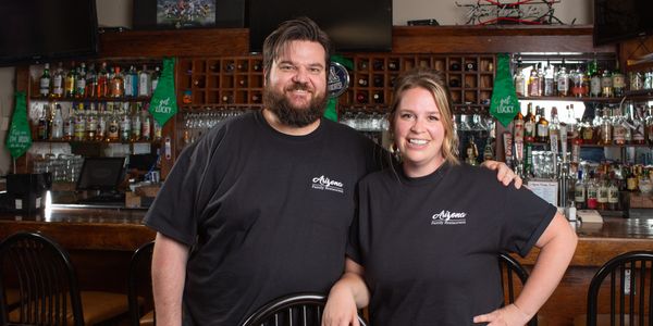 Image shows Katie and her husband in their restaurant.