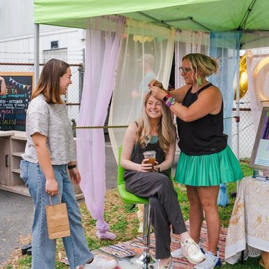 The Sparkle Bar vendor booth set up at a market where people book appointments for fairy hair.