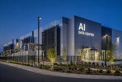 Exterior view of a modern AI data center building at dusk.