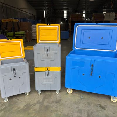 Stacked and wheeled coolers with yellow and blue lids in a warehouse.