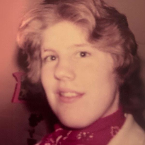 Portrait of a young person with a red scarf.
