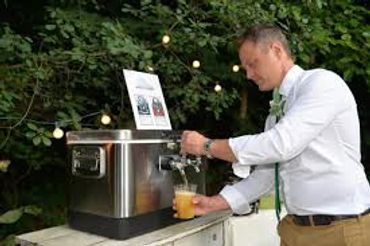 Man pouring a drink from a tap at an outdoor event.
