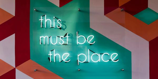 Image of a neon sign reading "this must be the place". Photo by Tim Mossholder on Unsplash