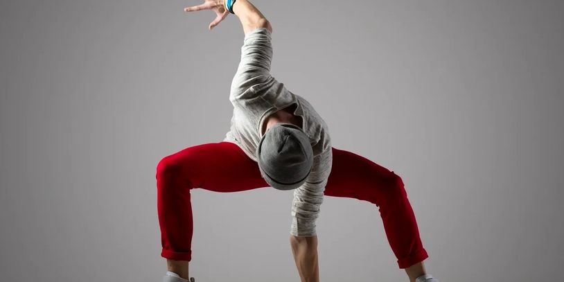 Urban male dancer striking pose with white background