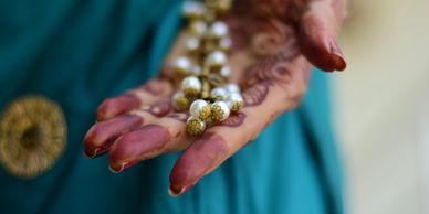 Henna painted hand holding pearls