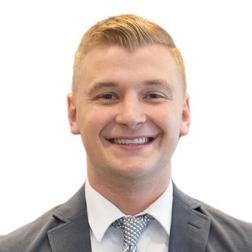 Smiling young man in a suit and tie against a white background.