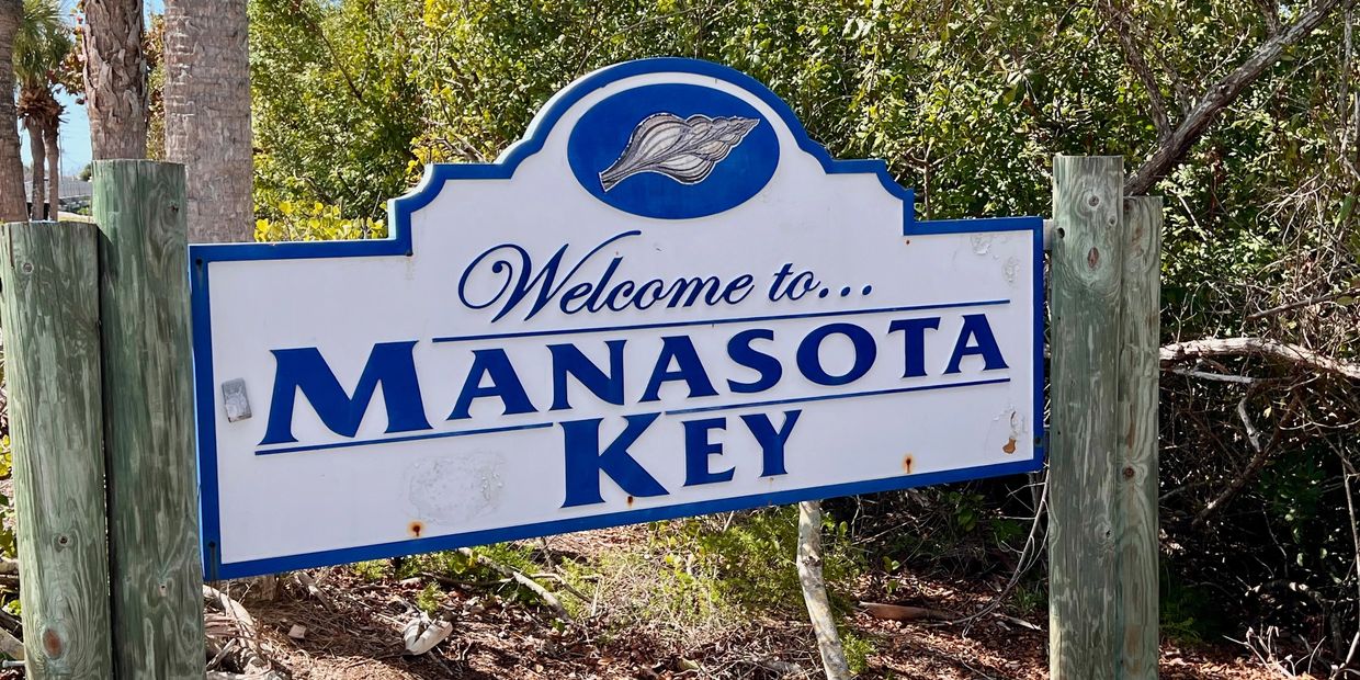 Welcome sign for Manasota Key with a seashell design.