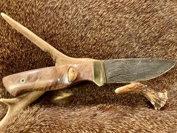 Handcrafted wooden-handled knife with a damascus blade.