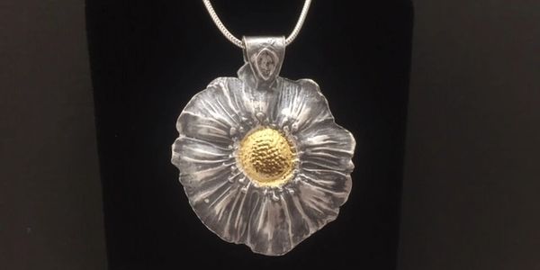 Made from .999 fine silver and 22K gold this flower necklace will brighten your day.