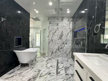 Luxurious bathroom with tile flooring and walls, featuring a clawfoot tub and modern shower.