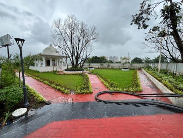 Garden with pavilion and cloudy sky.