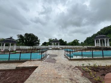 Three gazebos in a park on a cloudy day.