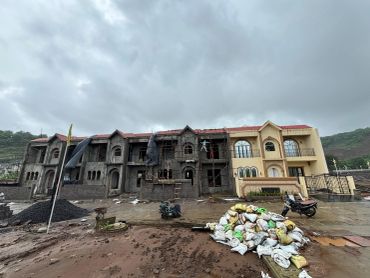 Half-built house with construction materials outside.