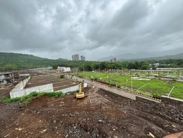 Construction site with cloudy sky and greenery around.