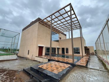 Modern house with outdoor pool under cloudy sky.
modern clubhouse with swimming pool at na plot township in third mumbai
mumbai third properties
sankalp meadows
riyasat infra
riyasat