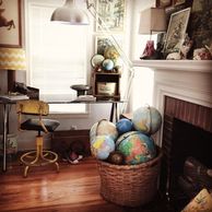 Serene Work Space, antique cotton basket of vintage globes, large industrial lamp, bohemian office, fireplace, paint by numbers on mantle