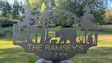 Metal sign with bear family and trees, reading 'The Ramsey's Est. 2004'.