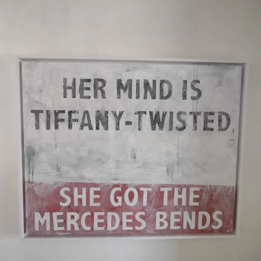 A wall art with a quirky phrase about a twisted mind and Mercedes bends.