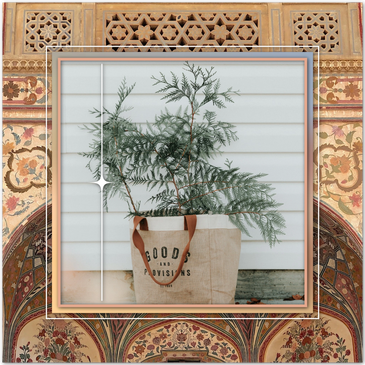 A bunch of Cedar branches with bushy deep green leaves sitting in a burlap bag planter