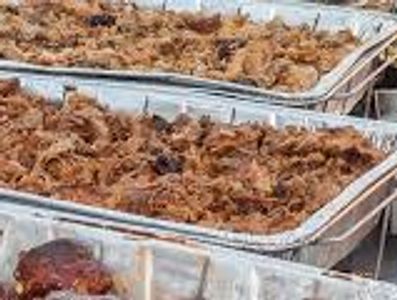 Trays filled with cooked shredded meat.
