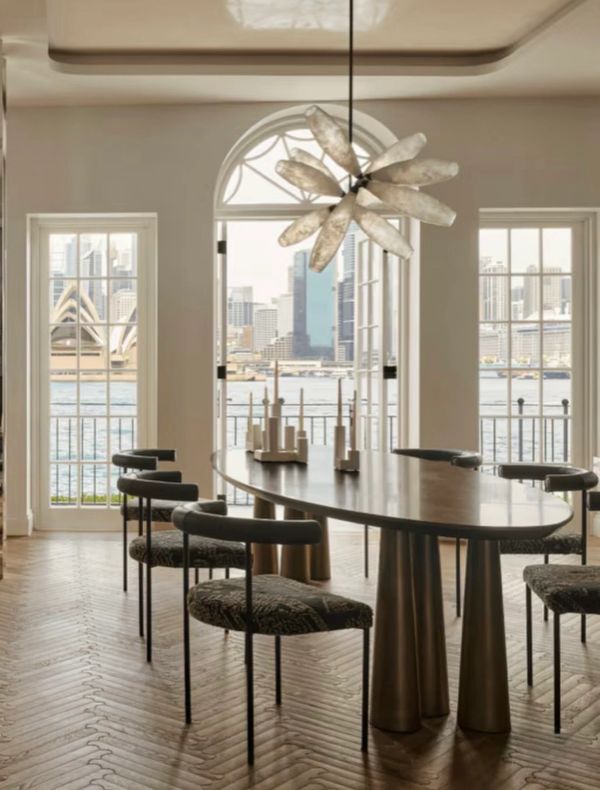 Elegant dining room with oval table and city view through large windows.