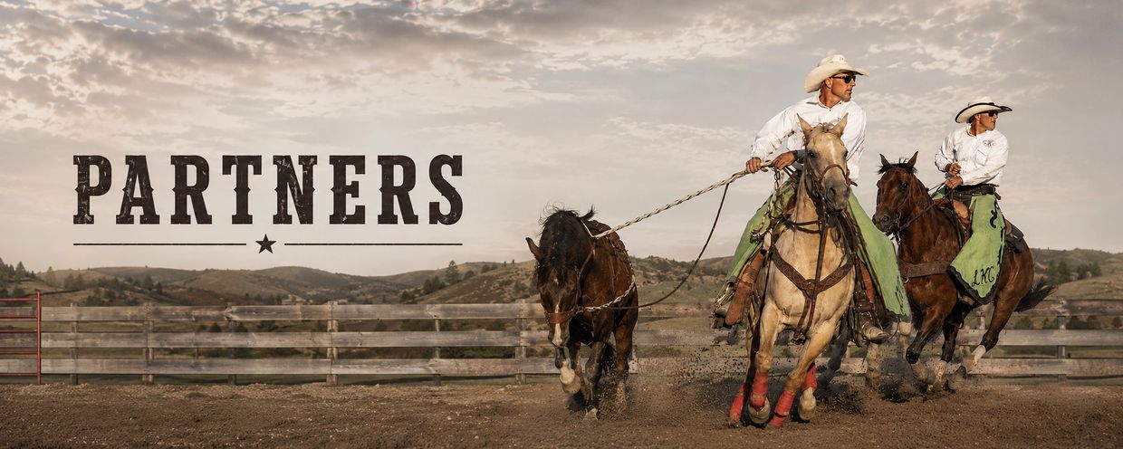 Two cowboys on horses roping a calf with 'PARTNERS' text.