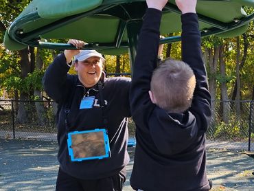 Child and therapist using an AAC system while playing on the playground.