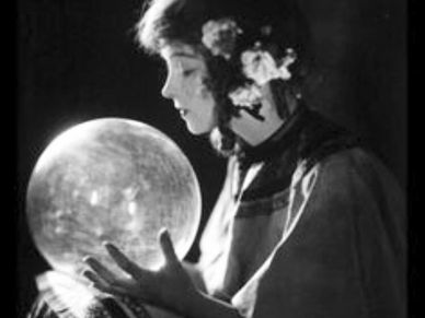 A woman holding a ball of crystal
