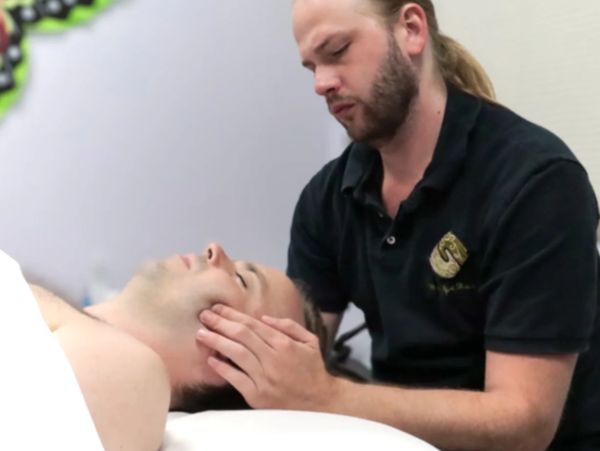 Massage therapist performing TMJ massage in Sugar Land, TX.