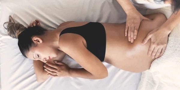 Pregnant woman on her side receiving prenatal massage therapy at Wholly Spirit Hands Sugar Land.