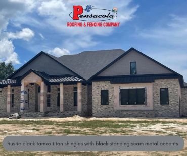 New house under construction with rustic black shingles and metal accents.