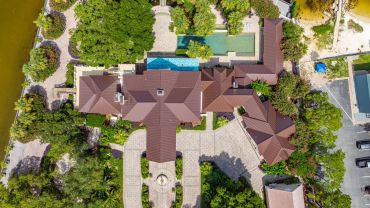 Aerial view of a large house with a swimming pool and garden.
