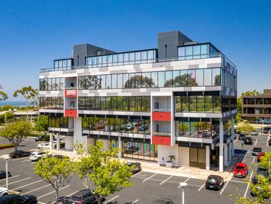 Modern office building with reflective windows under a clear blue sky.