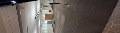 An empty office space with carpet flooring and some equipment scattered around.