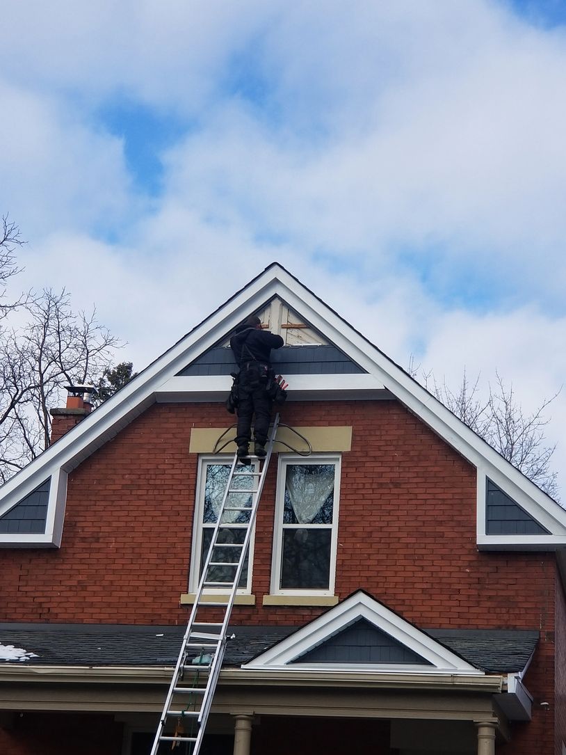Matt Kroh installing siding on 2 story gable on a home in London, Ontario.