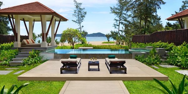 Luxurious poolside lounge area overlooking the ocean with shaded cabanas.