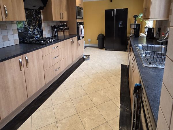 Modern kitchen with wooden cabinets and black appliances.