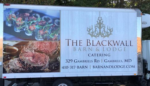 A catering company car with vehicle wraps advertising.