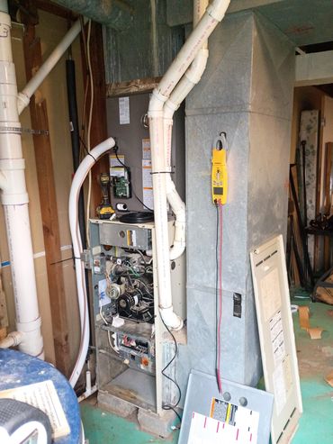 Open HVAC system with tools and pipes in a basement area. AC system installed in Reeds Spring, MO