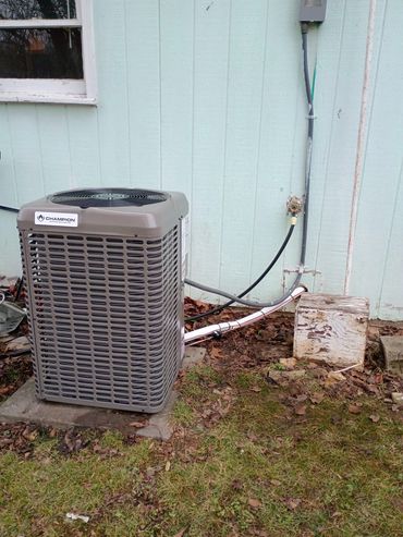 Outdoor air conditioning unit next to a house with connected pipes. Installed in Hartville, MO