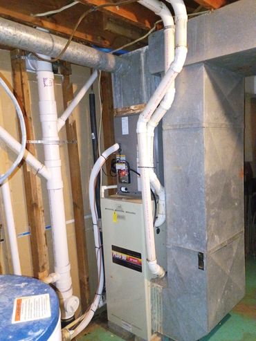 A basement furnace with ductwork and PVC pipes for ventilation and drainage.
Reeds Spring, MO