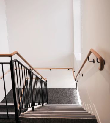 Staircase with handrail and stair treads and white painted walls.