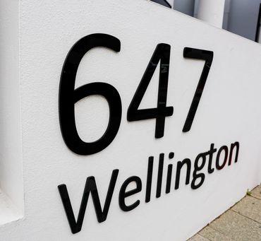 Black building signage on rendered wall.