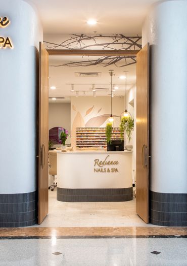 Shopfront entry with soft curves, natural palette and layered textures.